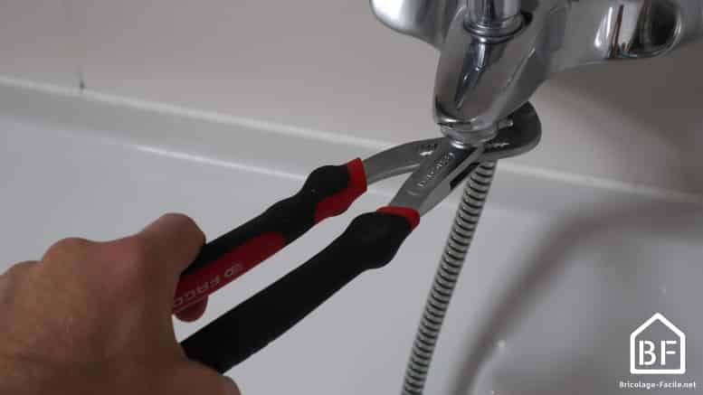 utilisation d'une pince multiprise pour dévisser le raccord du robinet de douche