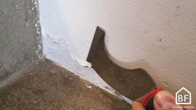 gratter un mur avec un couteau de peinture